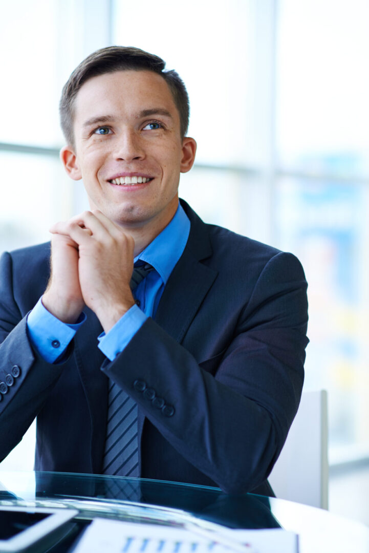 Cheerful businessman sitting at workplace in office